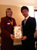 Vice President Eileen Charlton receives a pennant from Takumi Mieda from the Rotary Club of Sano in Japan
